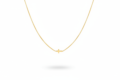 Delicate Gold Cross Necklace Hanging on White Background