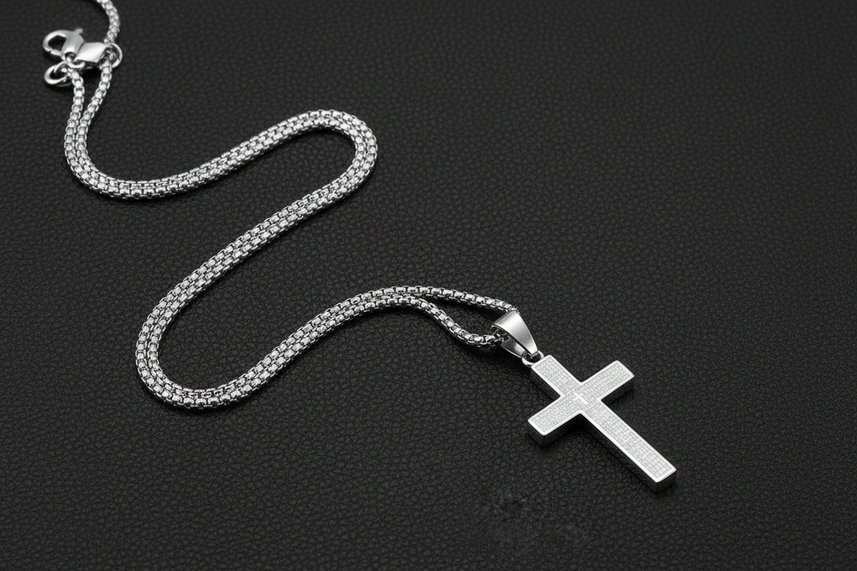 Silver cross necklace laid differently on black leather