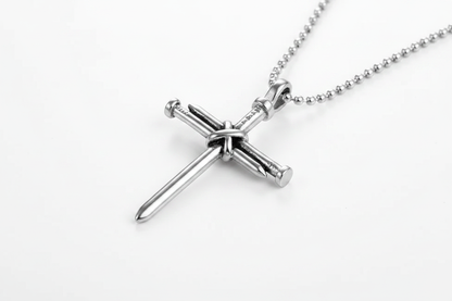 Silver nail cross pendant on white background
